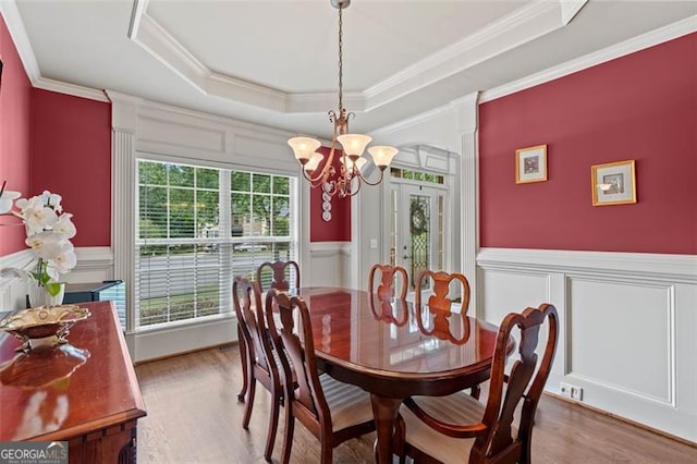 9065 Yellow Pine Ct, Gainesville, GA 30506 - dining room featuring a chandelier, a decorative wall, a raised ceiling, wood finished floors, and crown molding