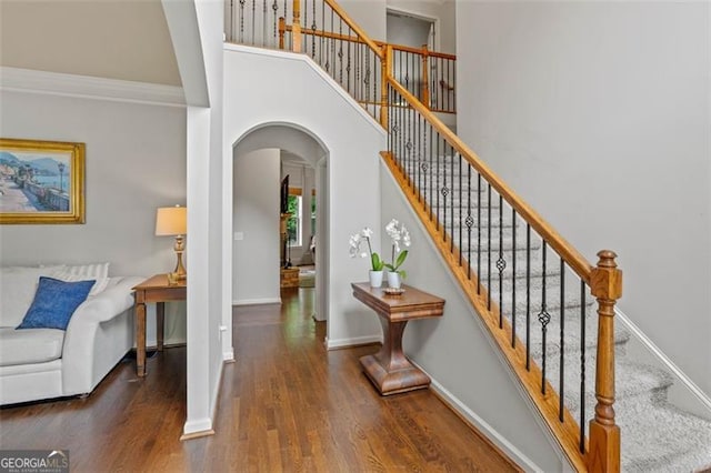 9065 Yellow Pine Ct, Gainesville, GA 30506 - stairway featuring arched walkways, wood finished floors, a high ceiling, and crown molding
