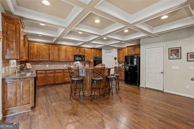 9065 Yellow Pine Ct, Gainesville, GA 30506 - kitchen with black appliances, brown cabinets, a kitchen bar, dark wood-type flooring, and beamed ceiling