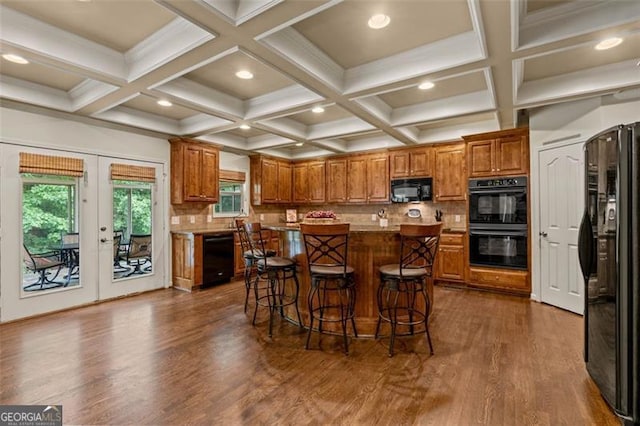 9065 Yellow Pine Ct, Gainesville, GA 30506 - kitchen with black appliances, brown cabinets, dark wood-style floors, a kitchen breakfast bar, and coffered ceiling