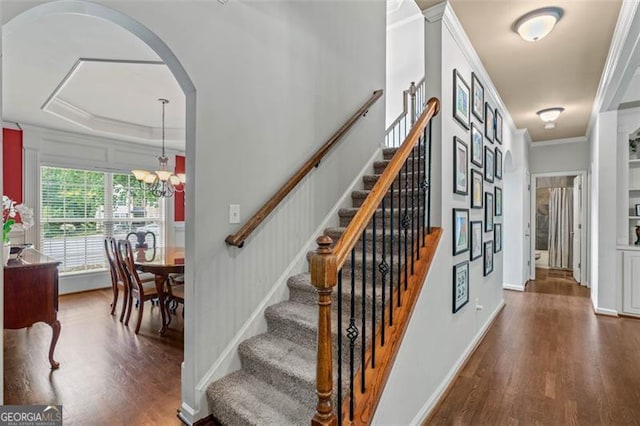 9065 Yellow Pine Ct, Gainesville, GA 30506 - stairs featuring wood finished floors, ornamental molding, arched walkways, and a chandelier