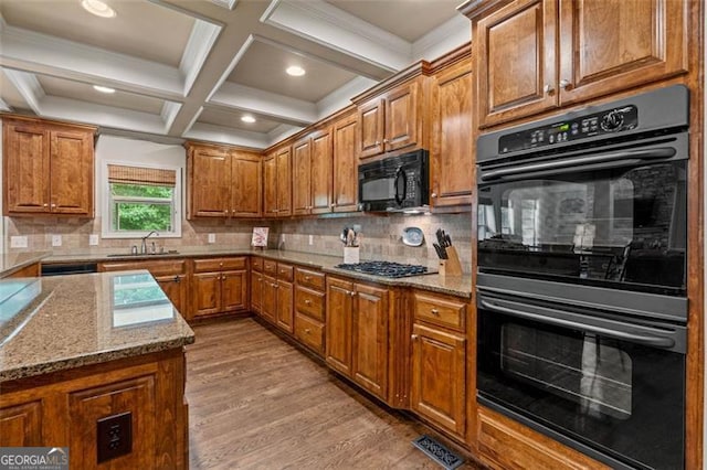 9065 Yellow Pine Ct, Gainesville, GA 30506 - kitchen featuring black appliances, brown cabinets, light wood-type flooring, beam ceiling, and light stone countertops