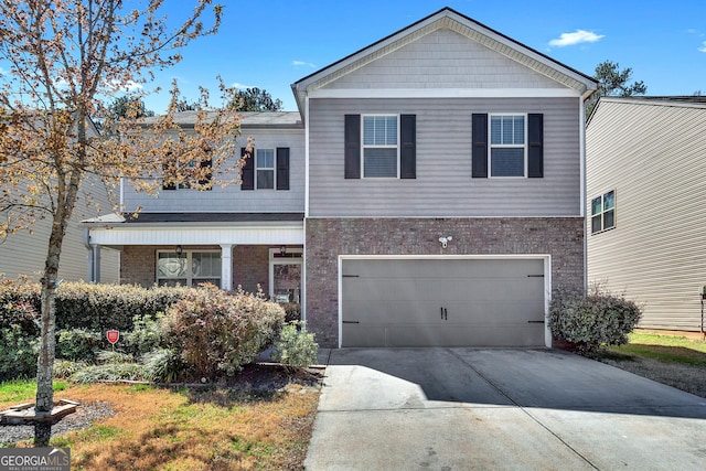 3929 Makeover Ct Unit 0, Atlanta, GA 30349 - view of front of home with brick siding, driveway, an attached garage, and covered porch