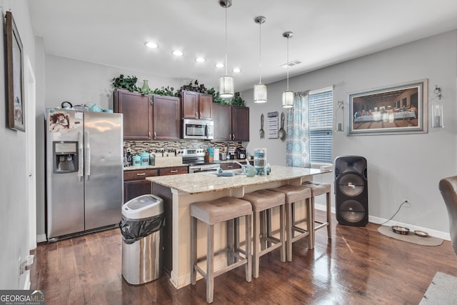 3929 Makeover Ct Unit 0, Atlanta, GA 30349 - kitchen with appliances with stainless steel finishes, dark wood-style flooring, dark brown cabinets, a breakfast bar area, and tasteful backsplash