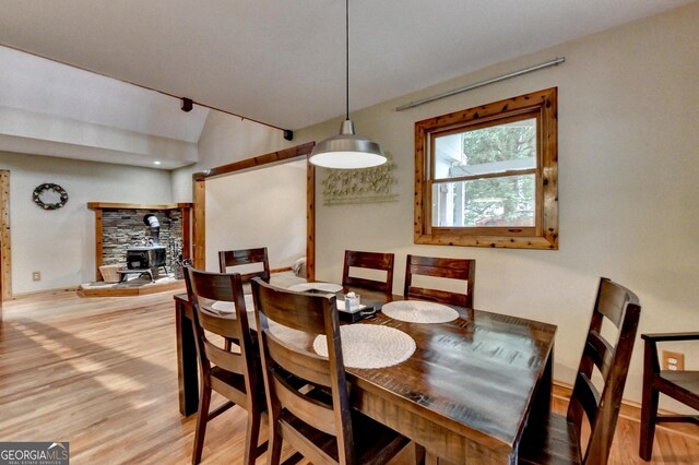 1365 Lower Creighton Rd, Cumming, GA 30028 - dining room featuring a wood stove, light wood-type flooring, and lofted ceiling