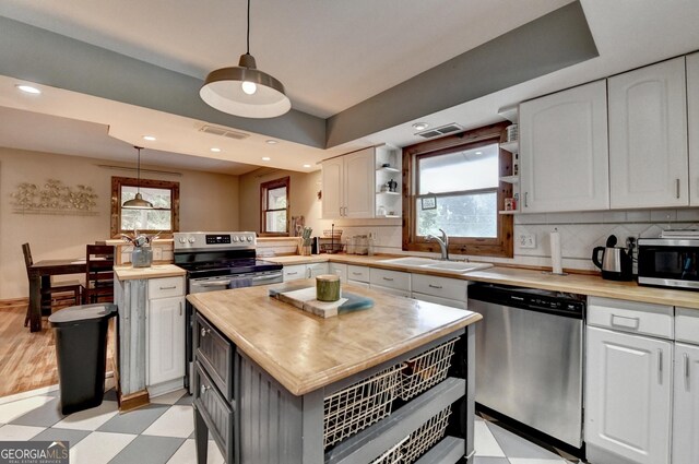 1365 Lower Creighton Rd, Cumming, GA 30028 - kitchen featuring appliances with stainless steel finishes, light floors, white cabinetry, wood counters, and pendant lighting