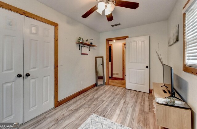 1365 Lower Creighton Rd, Cumming, GA 30028 - unfurnished bedroom with multiple windows, light wood-style floors, and a ceiling fan