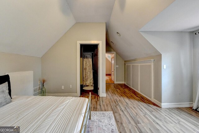 1365 Lower Creighton Rd, Cumming, GA 30028 - bedroom featuring light wood-style floors, lofted ceiling, a closet, and a spacious closet