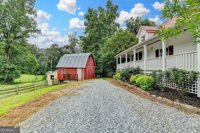 1365 Lower Creighton Rd, Cumming, GA 30028 - view of side of home with a barn, an outdoor structure, a metal roof, and a porch