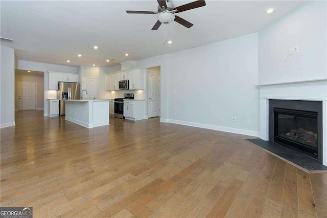 740 Pineberry Ct, Grayson, GA 30017 - unfurnished living room with ceiling fan, recessed lighting, light wood-type flooring, and a glass covered fireplace
