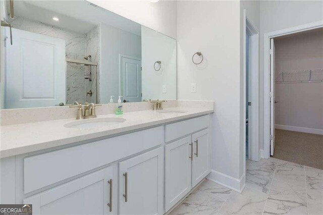 740 Pineberry Ct, Grayson, GA 30017 - bathroom with marble look tiles, a marble finish shower, double vanity, and a spacious closet