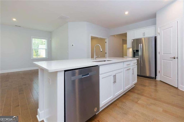740 Pineberry Ct, Grayson, GA 30017 - kitchen featuring appliances with stainless steel finishes, light wood-style flooring, light countertops, an island with sink, and recessed lighting