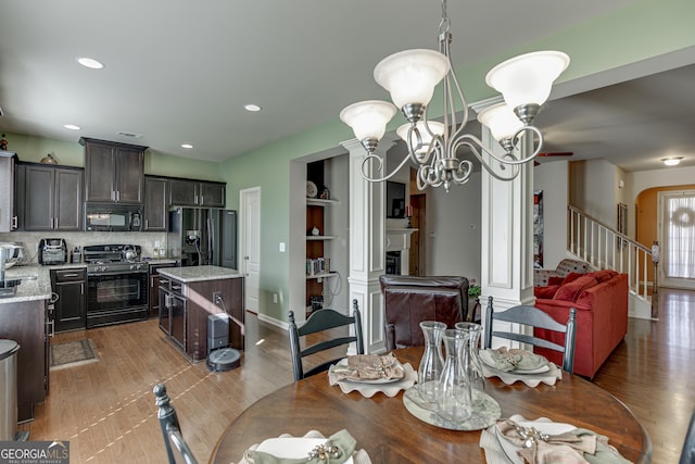 3393 Sardis Bend Dr, Buford, GA 30519 - dining area featuring a chandelier, recessed lighting, a fireplace, light wood-style flooring, and stairs