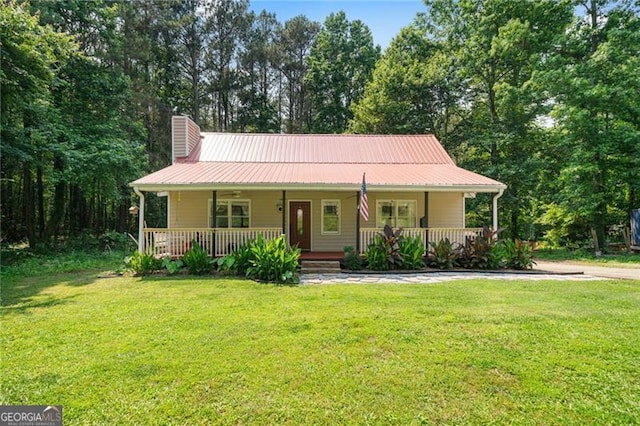 76 Beech Creek Cir, Winder, GA 30680 - view of front of home with covered porch, a chimney, a front yard, and metal roof