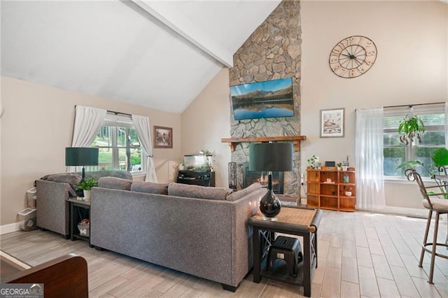 76 Beech Creek Cir, Winder, GA 30680 - living room with wood finished floors, high vaulted ceiling, a stone fireplace, beam ceiling, and baseboards