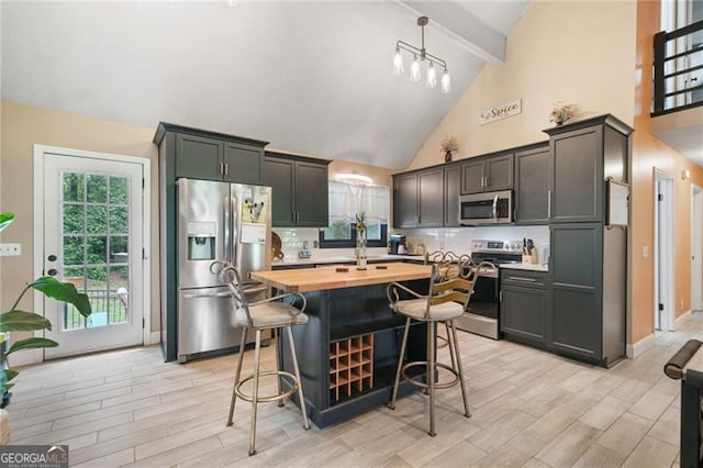 76 Beech Creek Cir, Winder, GA 30680 - kitchen with stainless steel appliances, wooden counters, beam ceiling, backsplash, and high vaulted ceiling