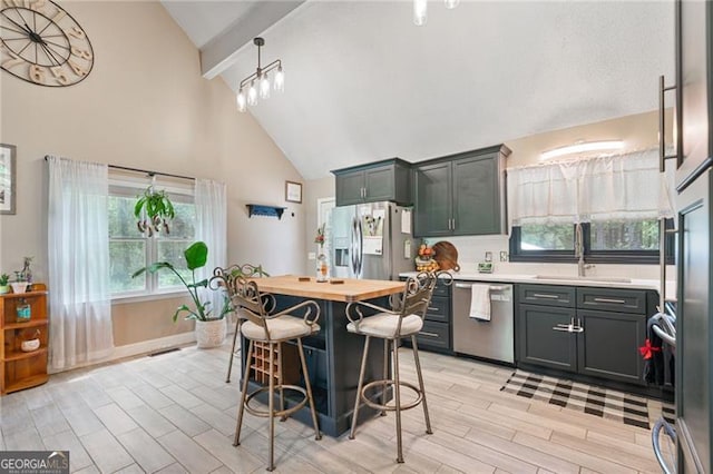 76 Beech Creek Cir, Winder, GA 30680 - kitchen featuring stainless steel appliances, a sink, high vaulted ceiling, wood finish floors, and a breakfast bar area