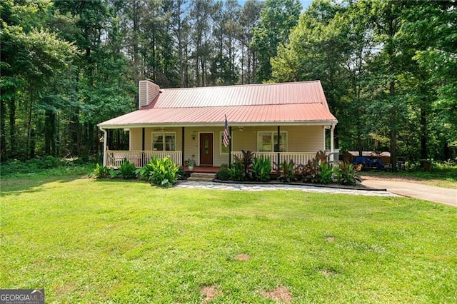 76 Beech Creek Cir, Winder, GA 30680 - view of front of house featuring a chimney, a porch, a front lawn, and metal roof