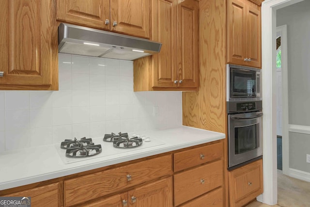 718 First Cotton Dr, Powder Springs, GA 30127 - kitchen featuring stainless steel oven, under cabinet range hood, built in microwave, white gas cooktop, and light countertops
