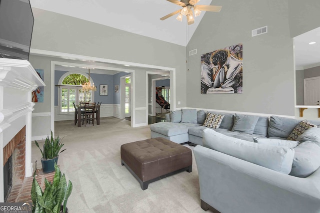 718 First Cotton Dr, Powder Springs, GA 30127 - living room with a brick fireplace, ceiling fan, high vaulted ceiling, light carpet, and a chandelier