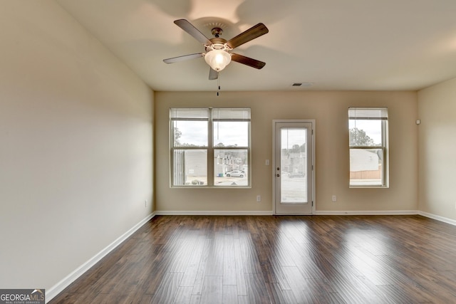 5831 Taka Ln, Lithonia, GA 30038 - empty room featuring healthy amount of natural light, ceiling fan, dark wood-style floors, and baseboards