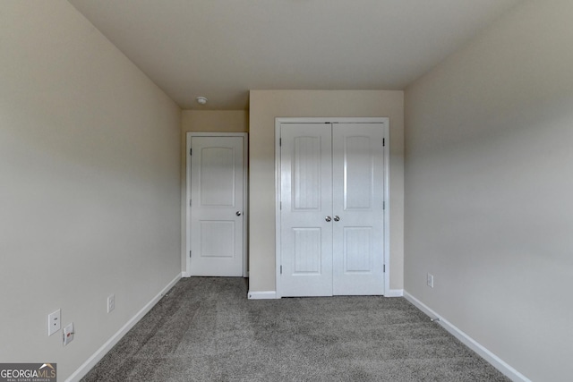 5831 Taka Ln, Lithonia, GA 30038 - unfurnished bedroom featuring dark carpet, baseboards, and a closet