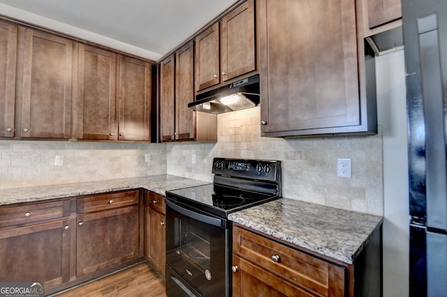 5831 Taka Ln, Lithonia, GA 30038 - kitchen with black range with electric cooktop, under cabinet range hood, decorative backsplash, and light wood-style flooring