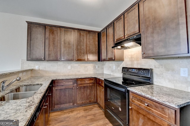 5831 Taka Ln, Lithonia, GA 30038 - kitchen featuring black / electric stove, under cabinet range hood, a sink, light stone countertops, and light wood-style floors