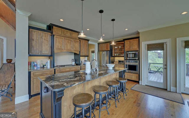 2156 Mockingbird Ln, Hiawassee, GA 30546 - kitchen with appliances with stainless steel finishes, crown molding, light wood-style flooring, brown cabinets, and a breakfast bar area