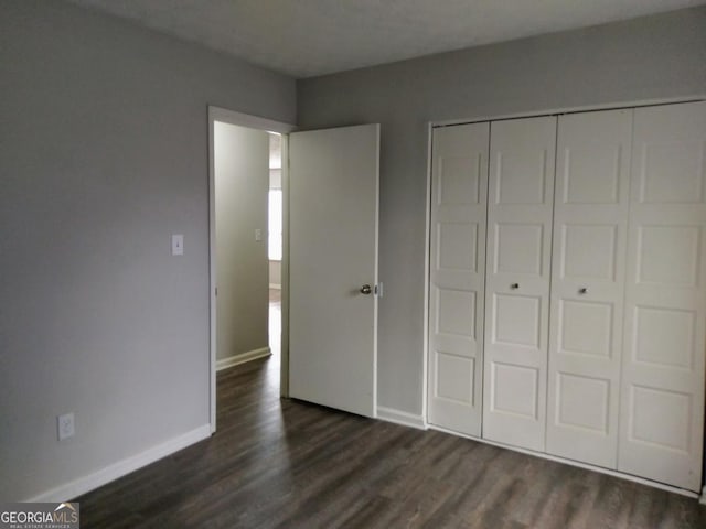 2566 Stratford Ln, Morrow, GA 30260 - unfurnished bedroom featuring dark wood-type flooring, baseboards, and a closet