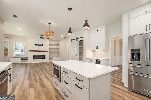 300 Windsor Chase Trl, Johns Creek, GA 30097 - kitchen featuring stainless steel appliances, a barn door, ceiling fan, light wood finished floors, and light countertops