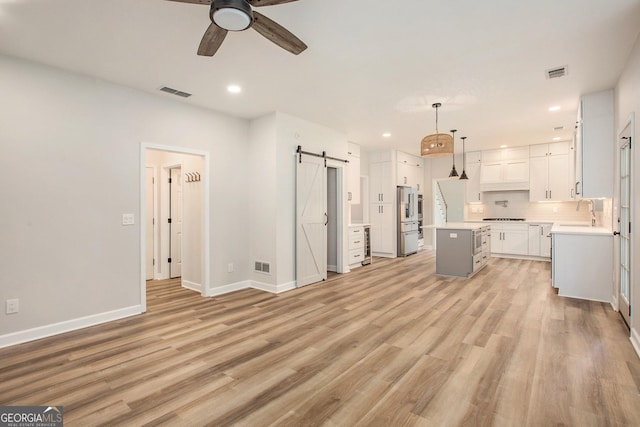 300 Windsor Chase Trl, Johns Creek, GA 30097 - unfurnished living room with a barn door, a ceiling fan, recessed lighting, light wood finished floors, and baseboards