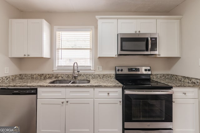 933 Capitol View Ave NW, Atlanta, GA 30318 - kitchen featuring appliances with stainless steel finishes, white cabinetry, and light stone counters