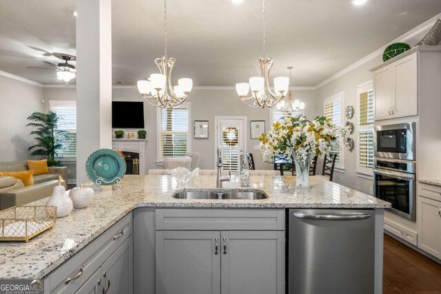 1604 Falcon Ct, Locust Grove, GA 30248 - kitchen featuring stainless steel appliances, open floor plan, a sink, a chandelier, and crown molding