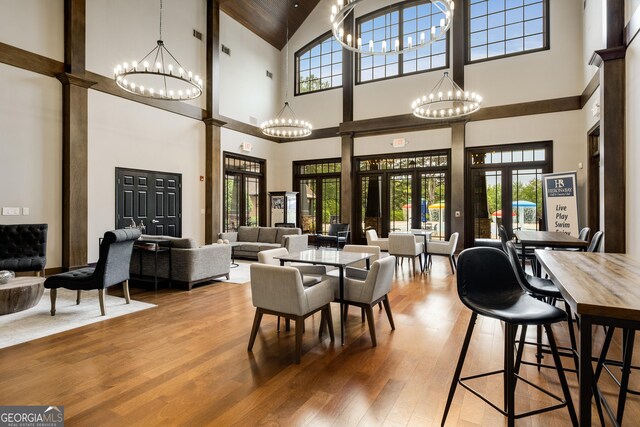 1604 Falcon Ct, Locust Grove, GA 30248 - dining area with high vaulted ceiling, a chandelier, wood finished floors, and healthy amount of natural light