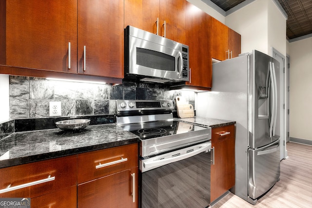 425 Chapel St SW Unit 1107, Atlanta, GA 30313 - kitchen featuring stainless steel appliances, light wood-style flooring, tasteful backsplash, dark stone counters, and brown cabinets