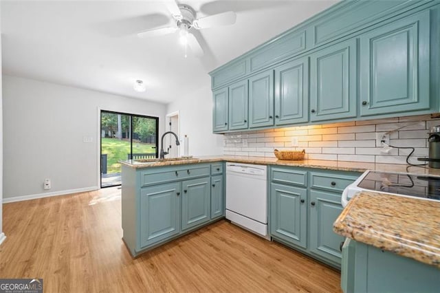 4458 Trickum Rd, Marietta, GA 30066 - kitchen with white appliances, a sink, a peninsula, light wood finished floors, and tasteful backsplash