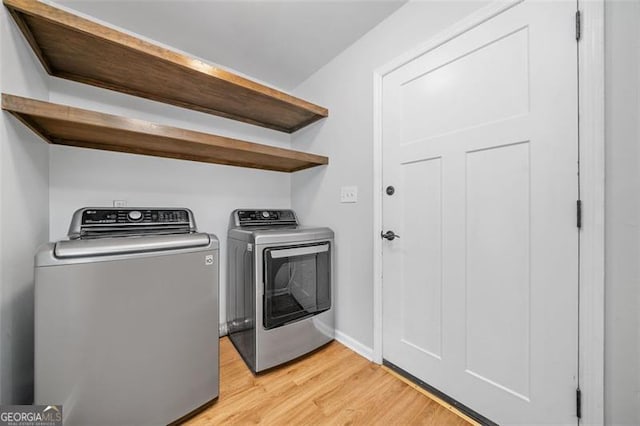 4458 Trickum Rd, Marietta, GA 30066 - laundry area with washing machine and clothes dryer, light wood-style floors, and baseboards