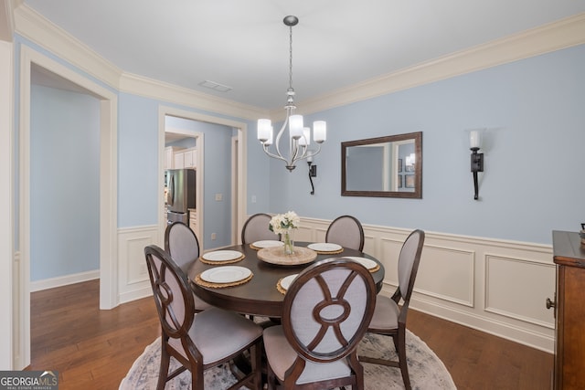 2245 Long Bow Chase, Kennesaw, GA 30144 - dining room featuring a chandelier, dark wood finished floors, a wainscoted wall, ornamental molding, and a decorative wall
