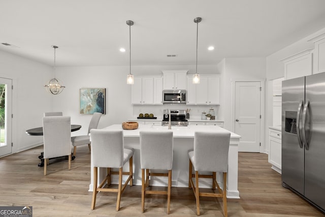 247 Annie Ln, Statham, GA 30666 - kitchen with appliances with stainless steel finishes, light countertops, decorative backsplash, a breakfast bar, and recessed lighting