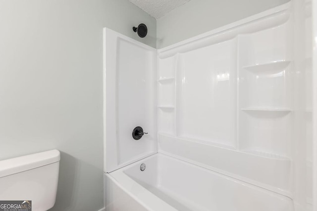 1017 Oak Ridge Dr, Byron, GA 31008 - bathroom featuring a textured ceiling, toilet, and shower / tub combination