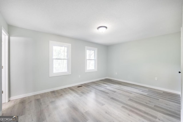 1017 Oak Ridge Dr, Byron, GA 31008 - spare room featuring light wood-style flooring, baseboards, and a textured ceiling