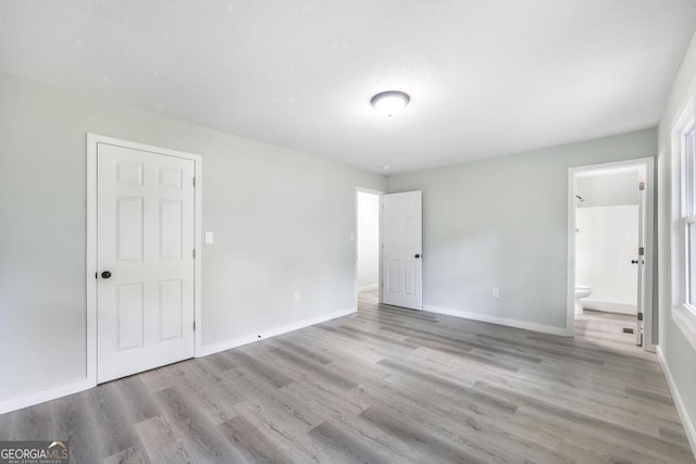1017 Oak Ridge Dr, Byron, GA 31008 - unfurnished bedroom featuring wood finished floors, baseboards, and ensuite bath