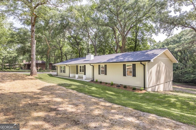 1017 Oak Ridge Dr, Byron, GA 31008 - ranch-style home with a chimney, a front lawn, view of wooded area, and a porch