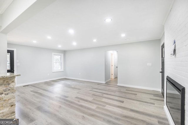 1017 Oak Ridge Dr, Byron, GA 31008 - unfurnished living room featuring recessed lighting, ornamental molding, light wood-type flooring, a large fireplace, and baseboards