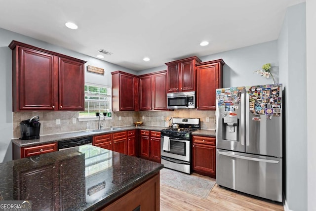 154 Stephens Mill Dr, Dallas, GA 30157 - kitchen with appliances with stainless steel finishes, dark brown cabinets, dark stone countertops, backsplash, and recessed lighting