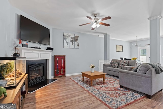 154 Stephens Mill Dr, Dallas, GA 30157 - living room with ornate columns, light wood-style flooring, a ceiling fan, and a chandelier