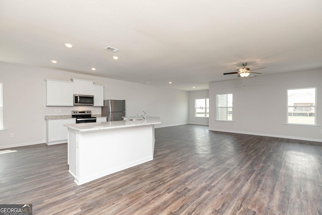 268 Oliver Dr, Locust Grove, GA 30248 - kitchen with stainless steel appliances, a sink, a kitchen island with sink, baseboards, and white cabinetry