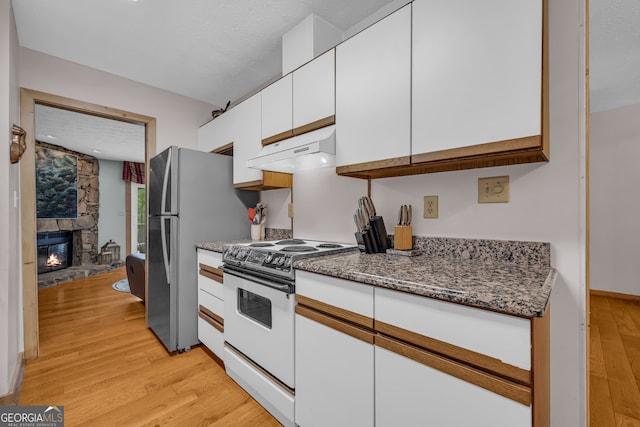 327 Brucken Strasse Unit 609, Helen, GA 30545 - kitchen with under cabinet range hood, white range with electric cooktop, white cabinetry, light wood-style flooring, and freestanding refrigerator