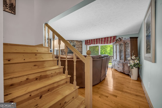 327 Brucken Strasse Unit 609, Helen, GA 30545 - stairway featuring wood-type flooring, a textured ceiling, and baseboards